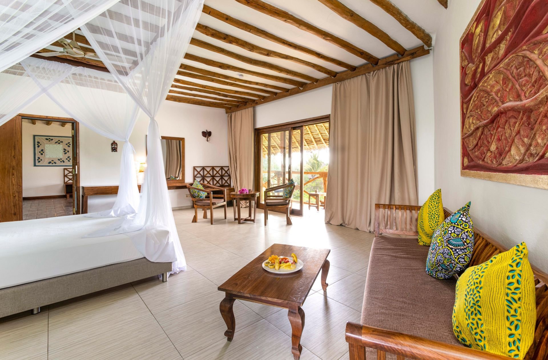 Suite with a four-poster bed under a makuti roof