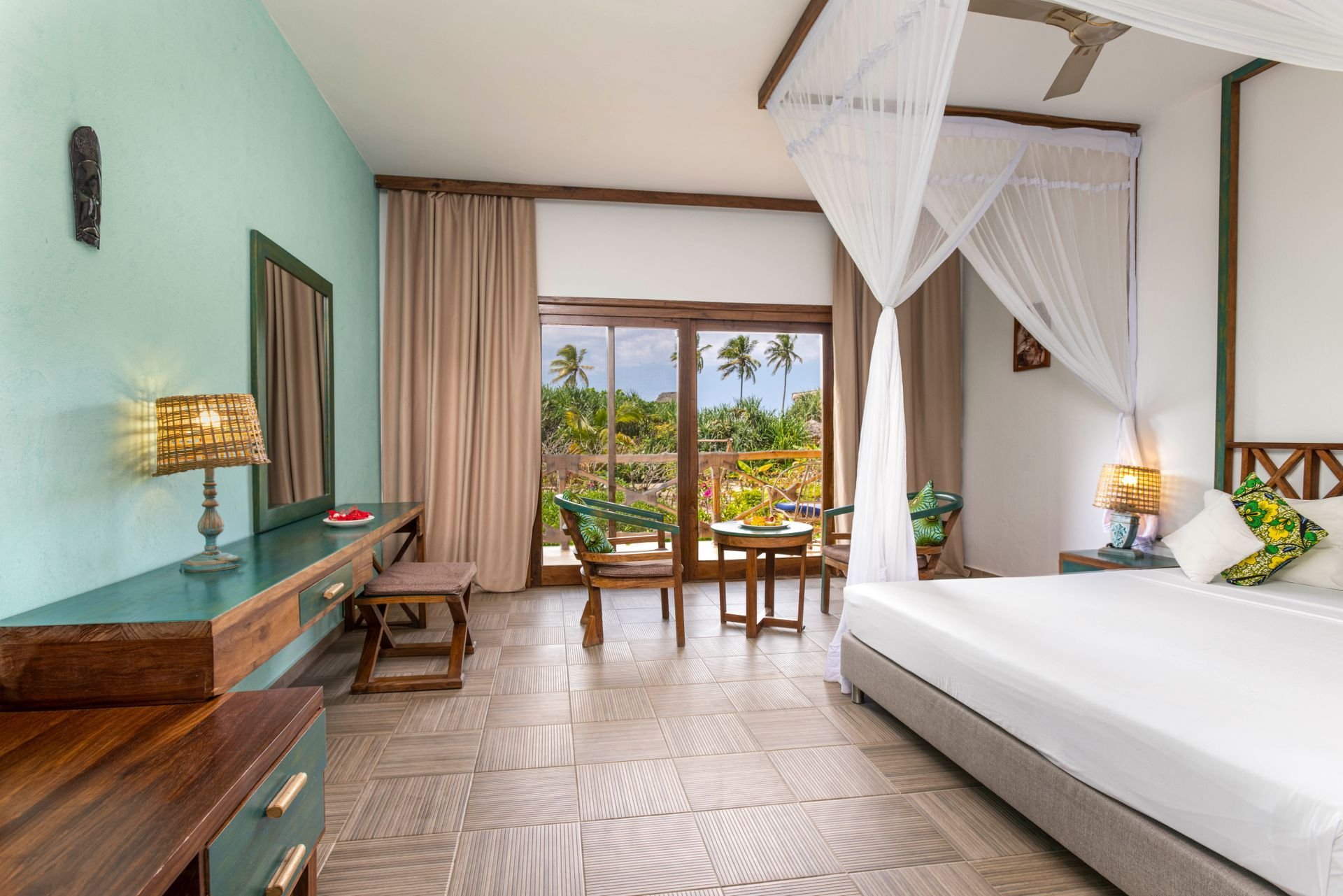 Bright bedroom with a four-poster bed and a balcony to the palms